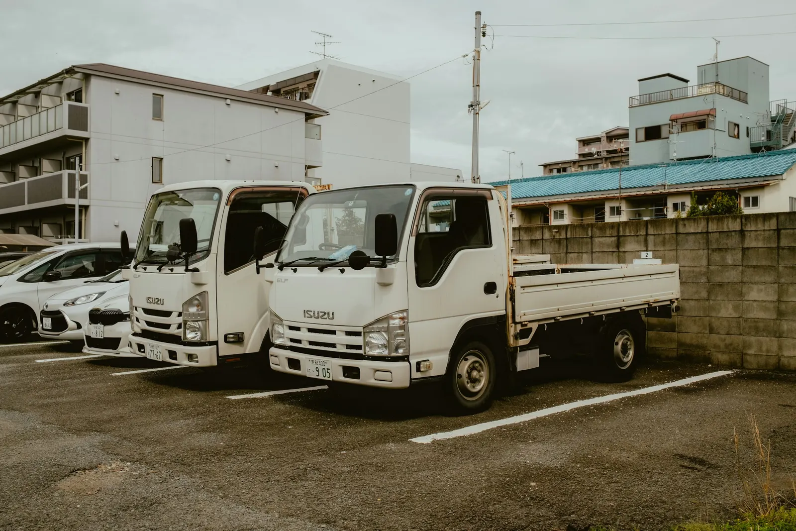 Two white flatbed lorries parked side by side